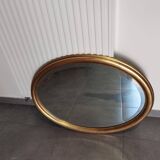 Large and elegant oval gilded mirror with its beveled glass