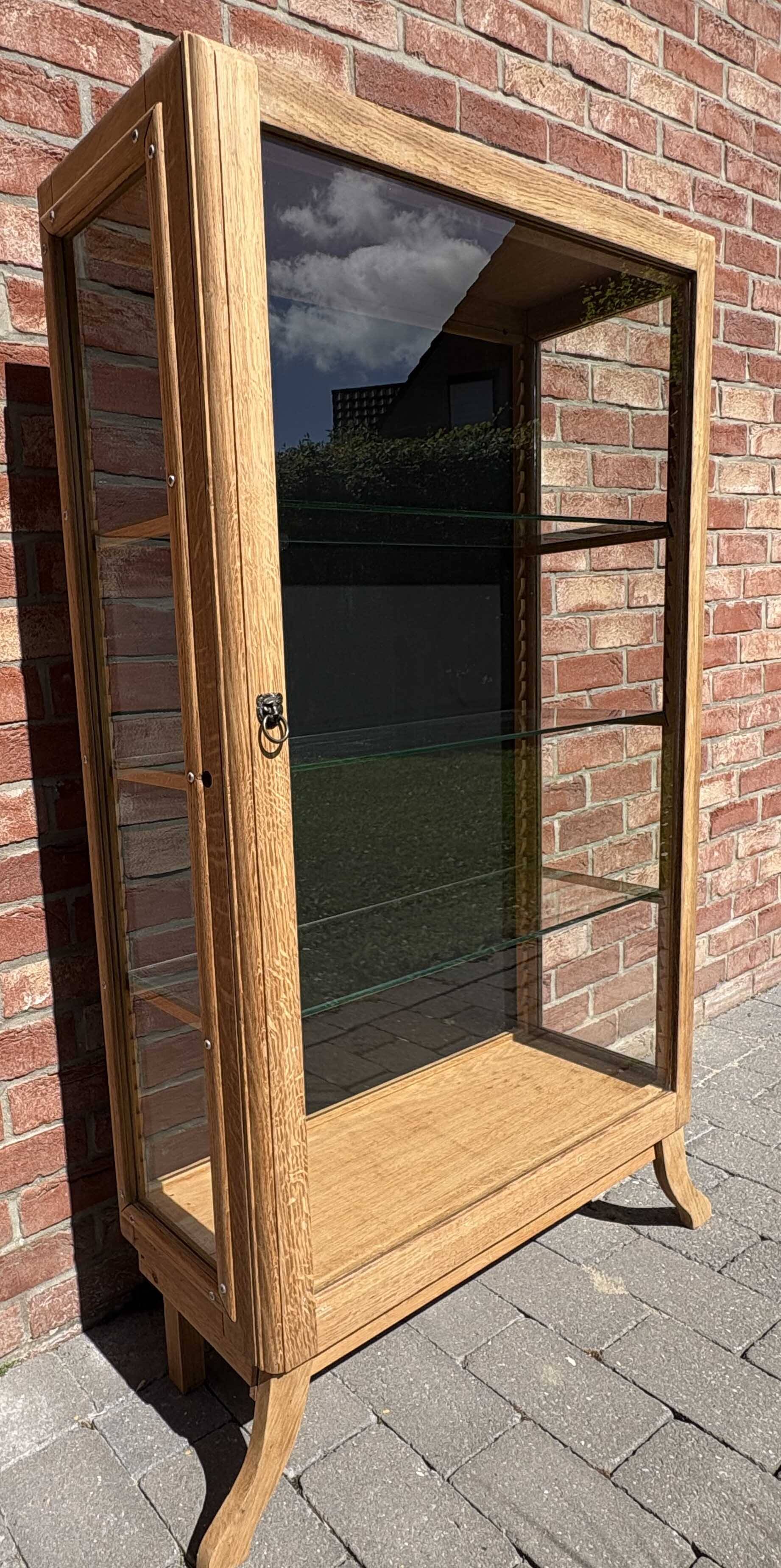 Restored antique oak display cabinet, black background, glass shelves.