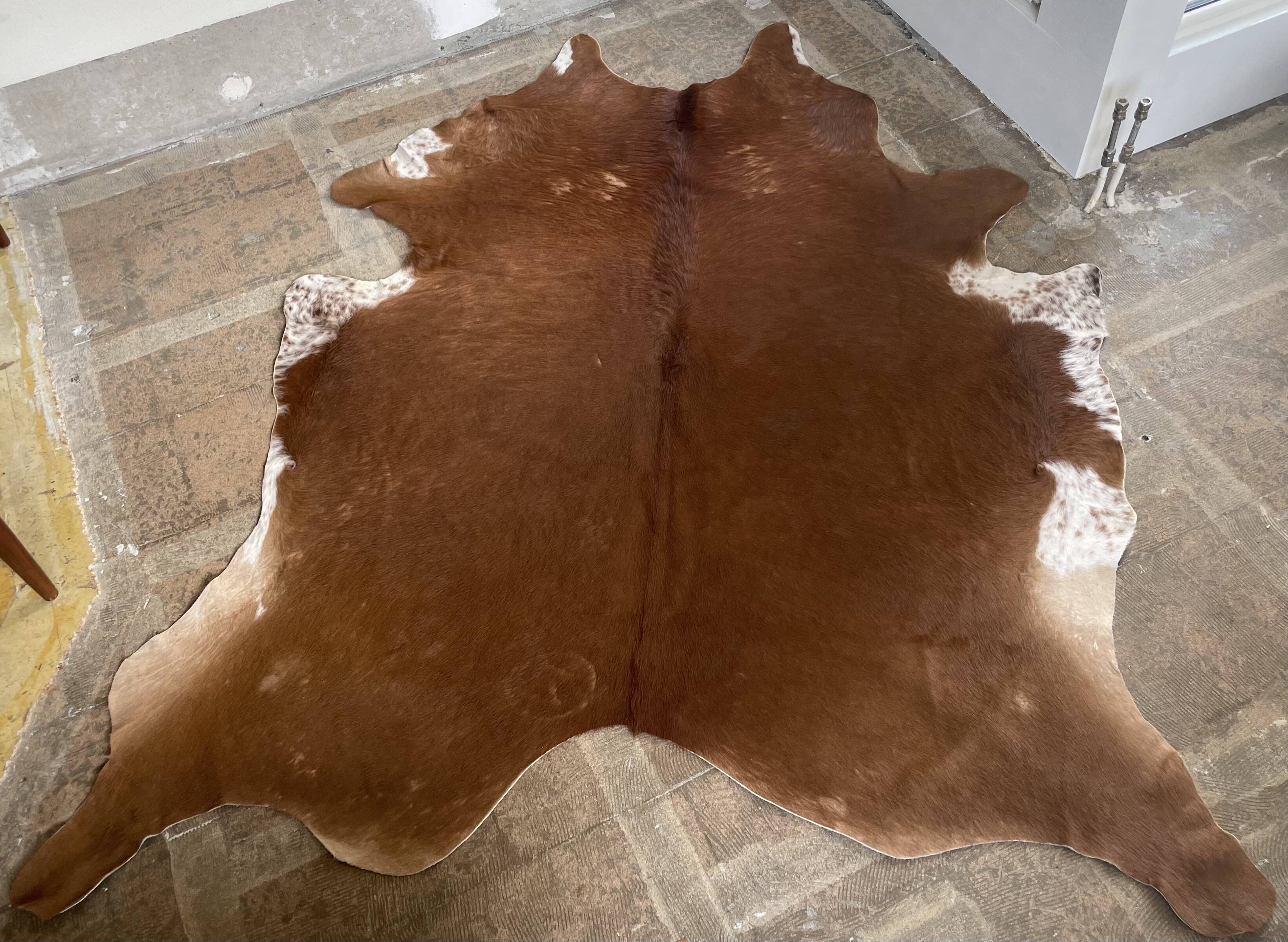 Brown and white cow rug