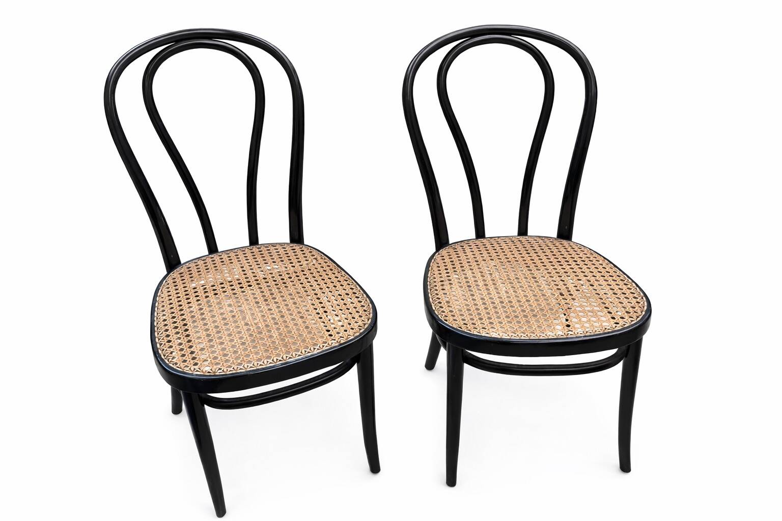 Pair of black curved wooden bistro chairs with caning in Thonet style.