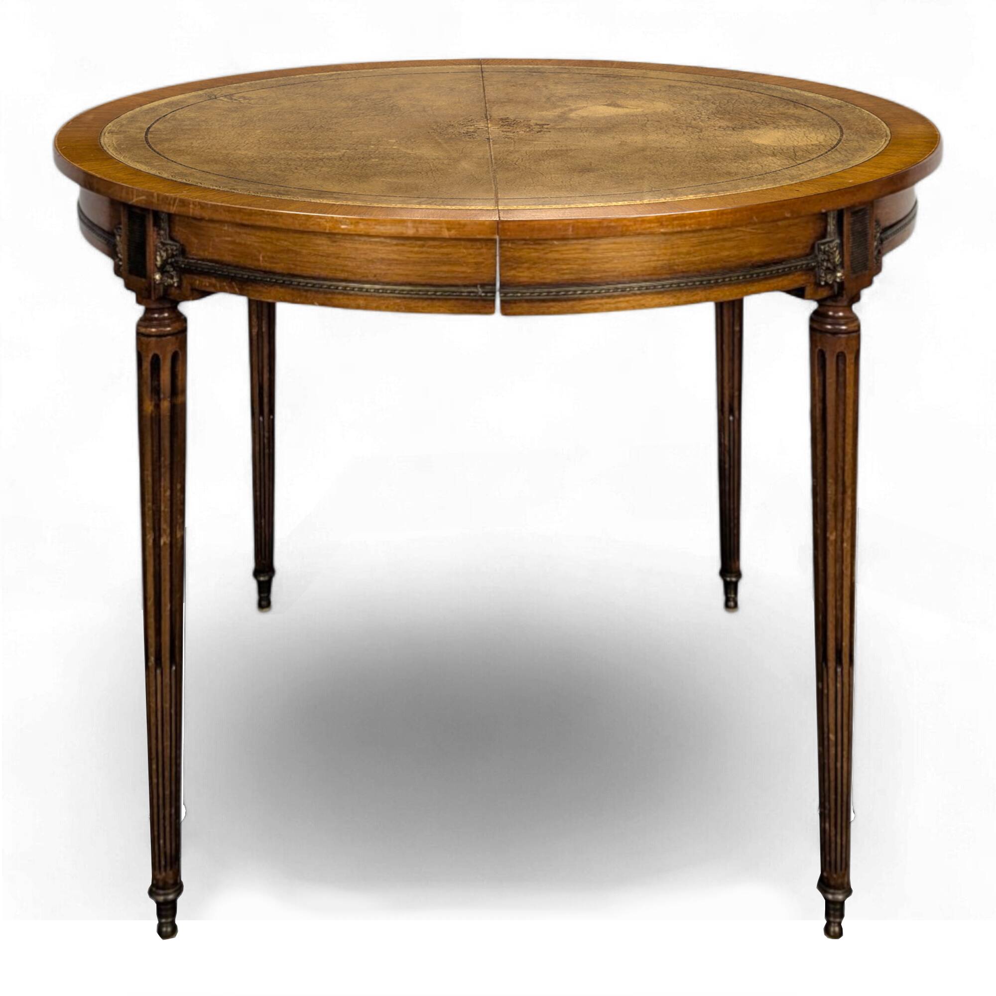 Louis XVI style dining table with a leather top.