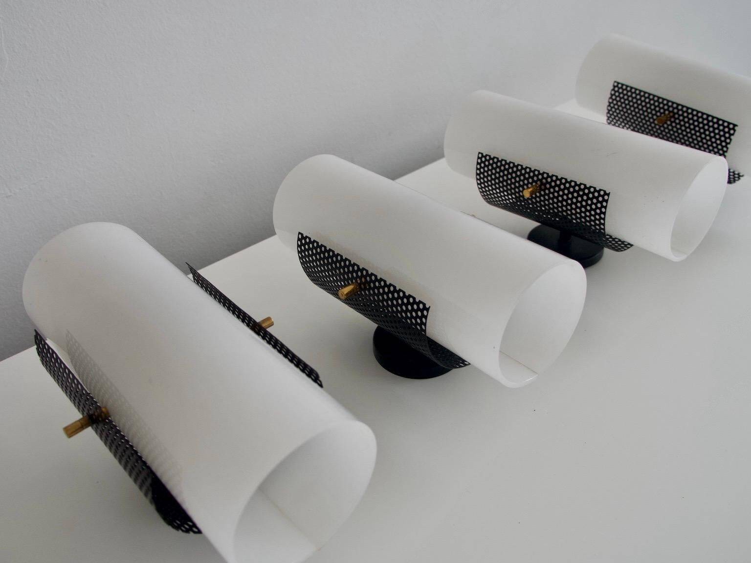 Set of four wall lights in white plexiglass and perforated black metal.