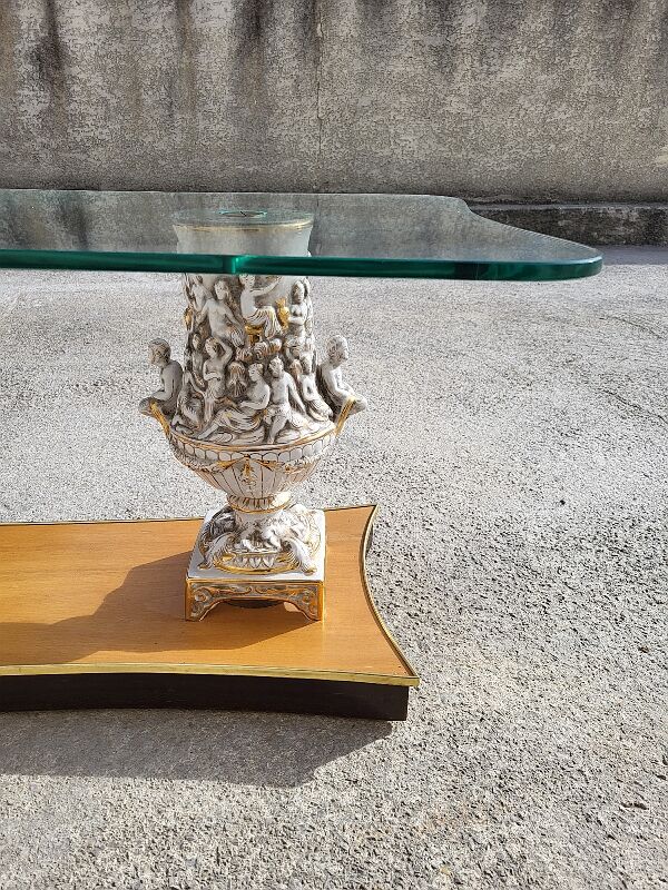 Italian coffee table with glass top, wooden base, and porcelain legs