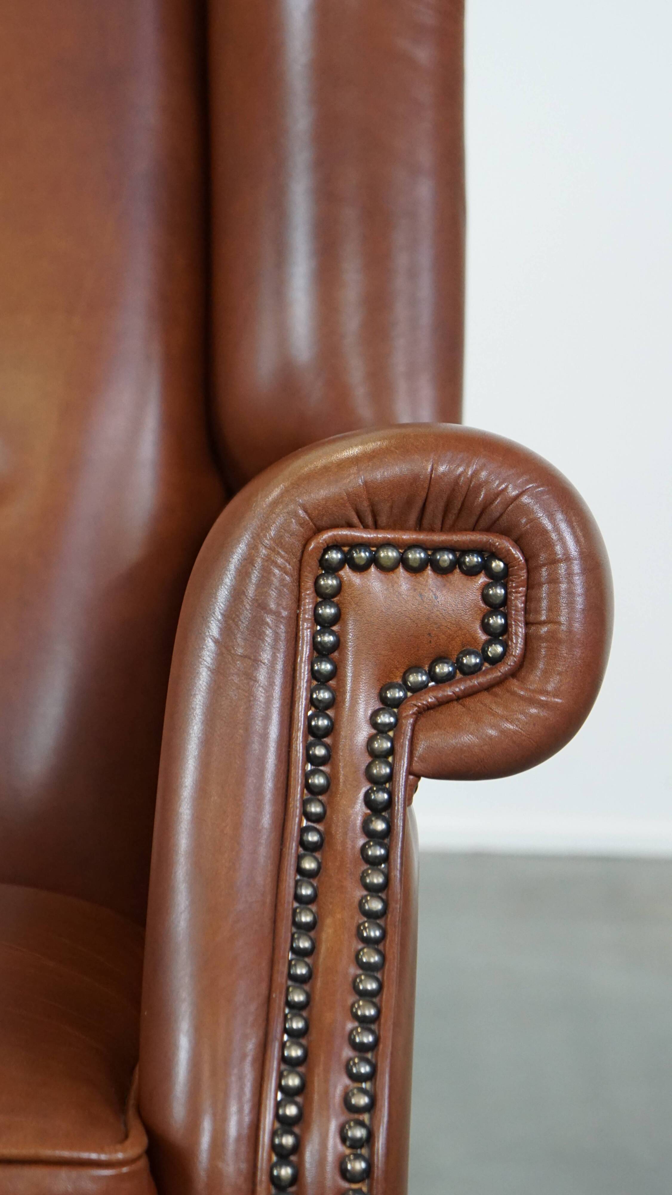 Cognac-colored leather wingback chair in English style