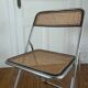 Vintage folding chair in metal and cane.