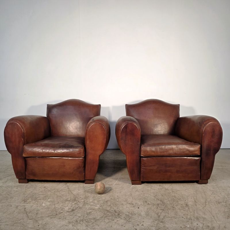 Important pair of Havana leather club armchairs, moustache models, mid-20th century.