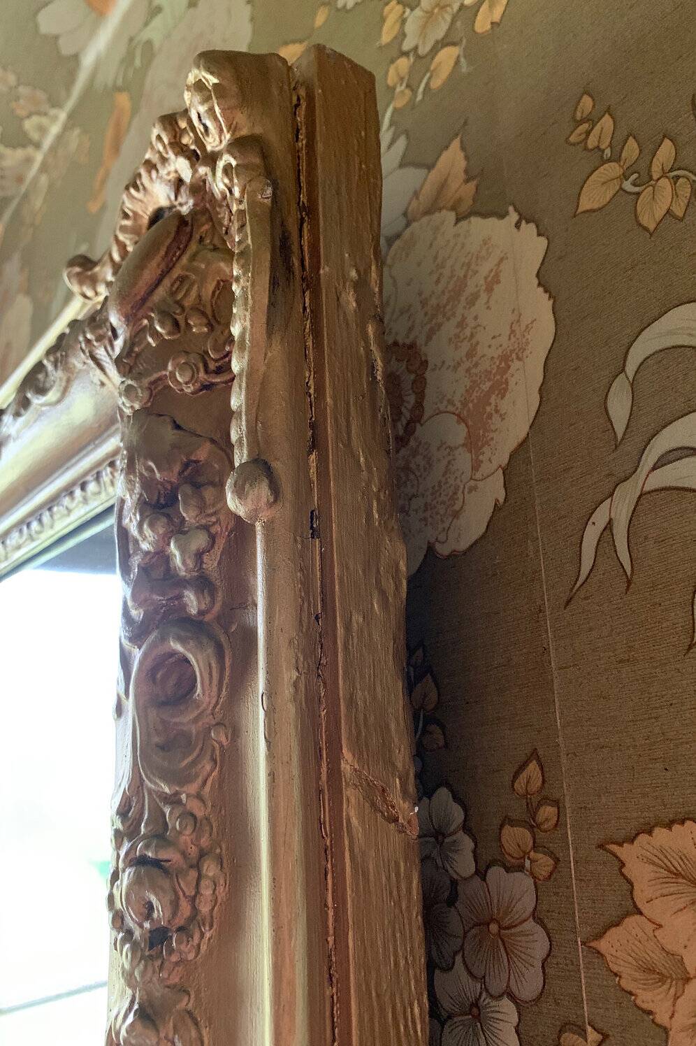 Miroir ancien en bois sculpté doré à décor de fleurs