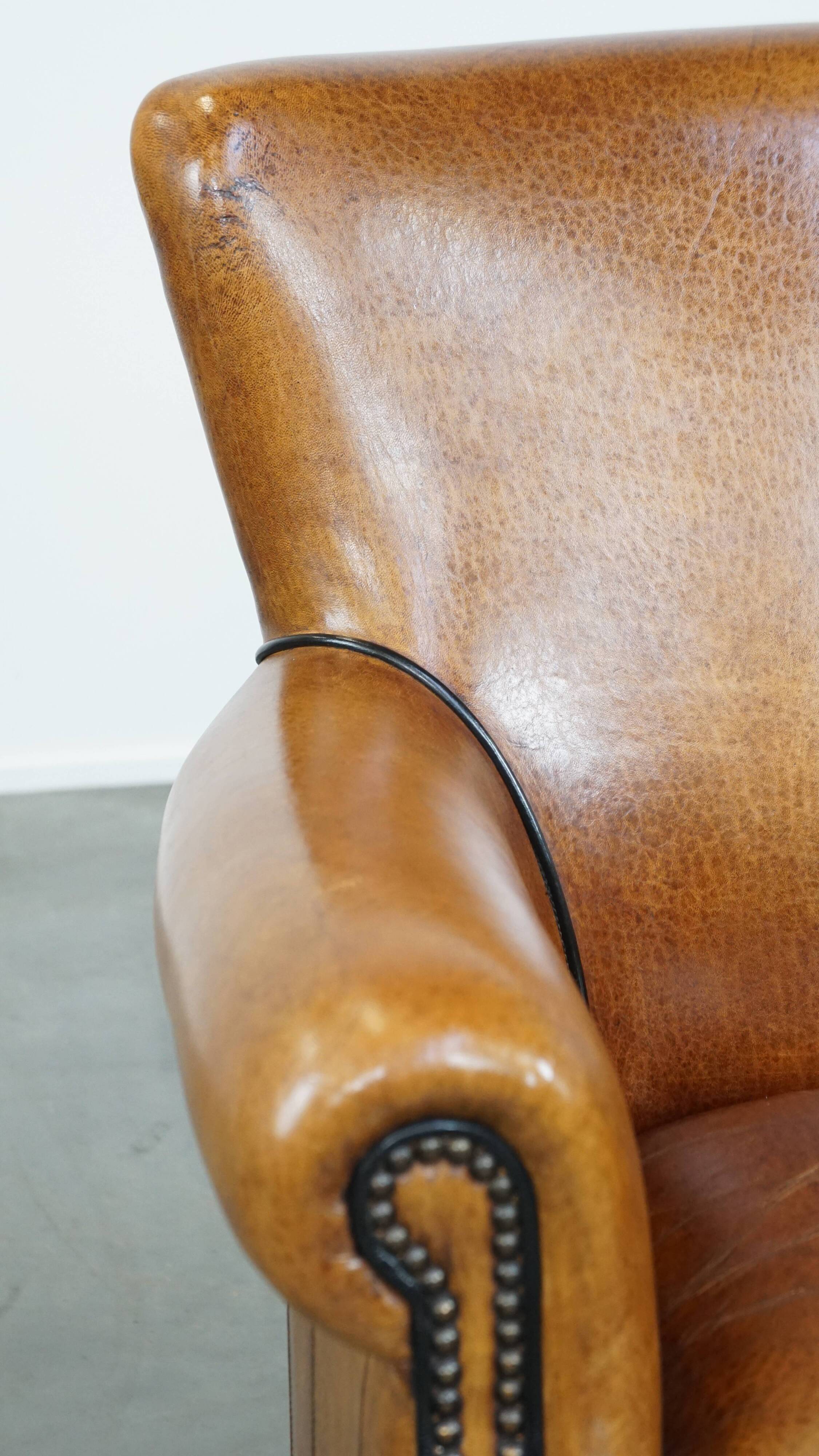 Cognac-colored sheep leather armchair finished with decorative nails