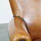 Cognac-colored sheep leather armchair finished with decorative nails