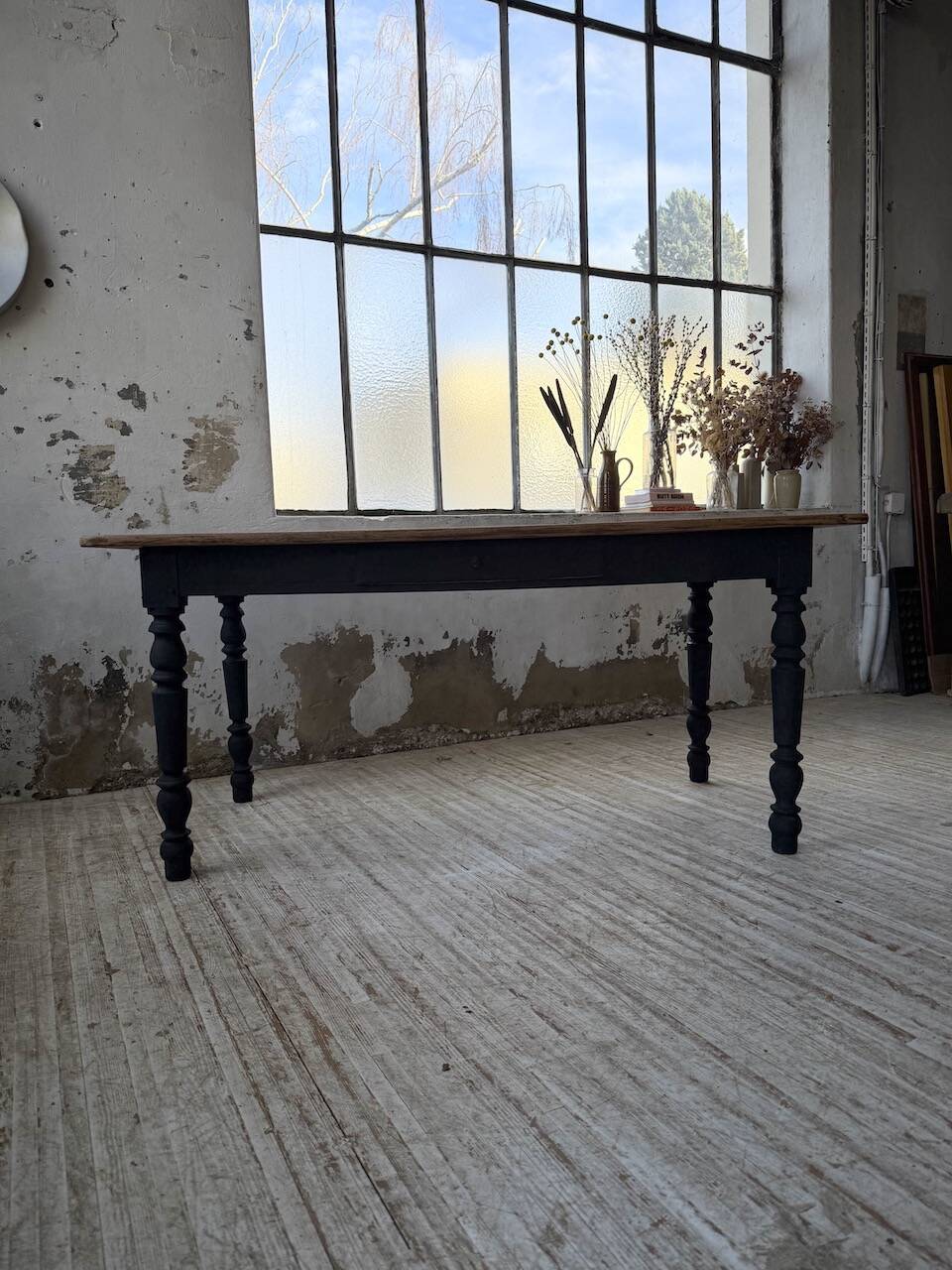 Oak farmhouse table with turned black legs.