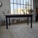 Oak farmhouse table with turned black legs.