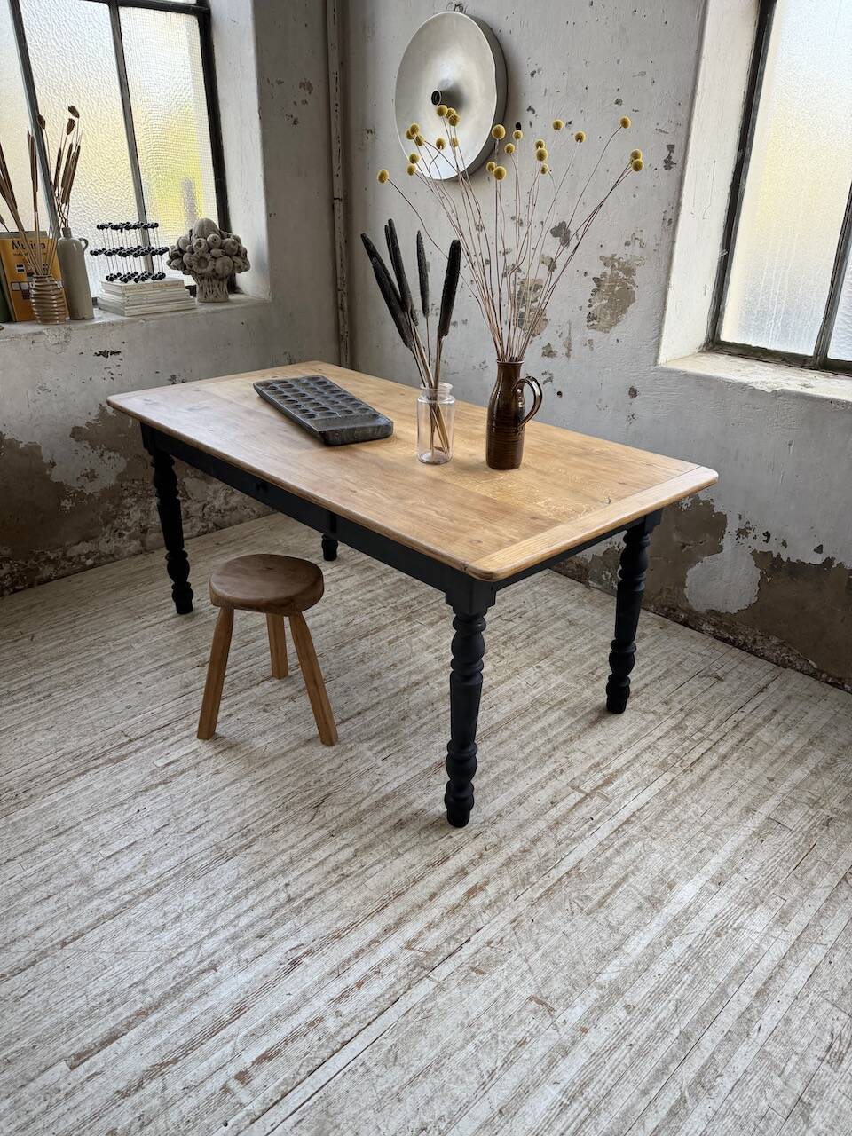 Oak farmhouse table with turned black legs.