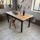 Oak farmhouse table with turned black legs.