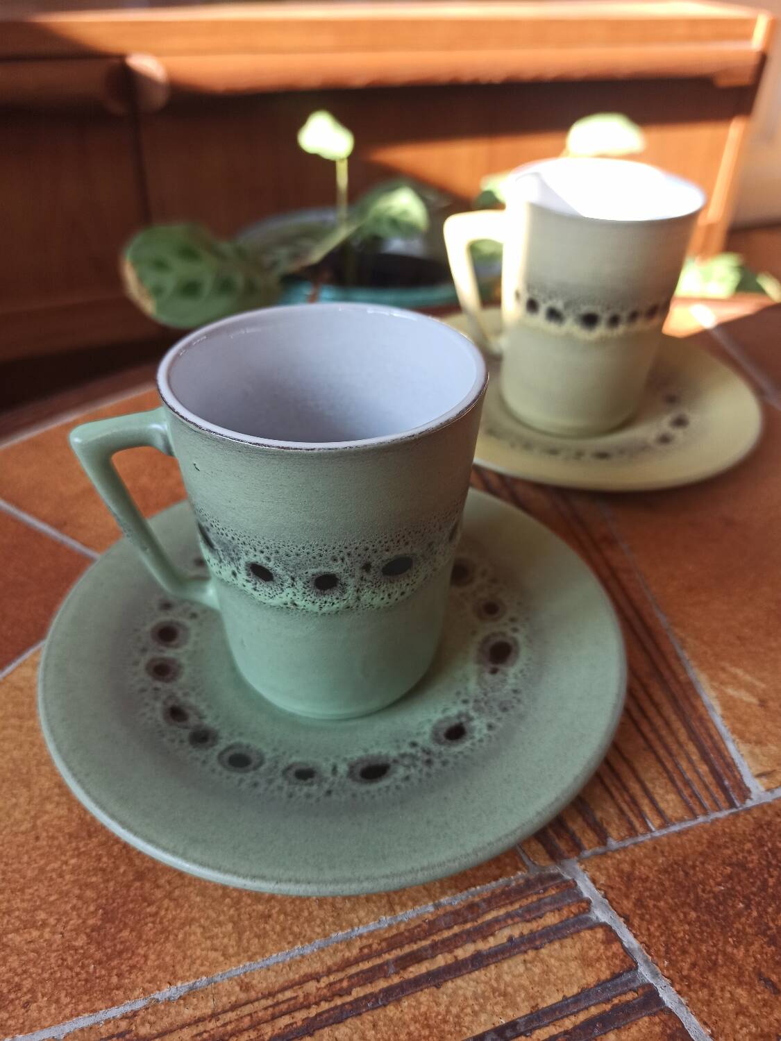 A pair of vintage glazed stoneware cups and saucers.