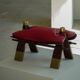 Moroccan stool in the shape of a camel saddle, stained wood, brass and leather, North Africa, 1980.