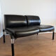 Vintage 2-seater banquette in black faux leather – 1980s