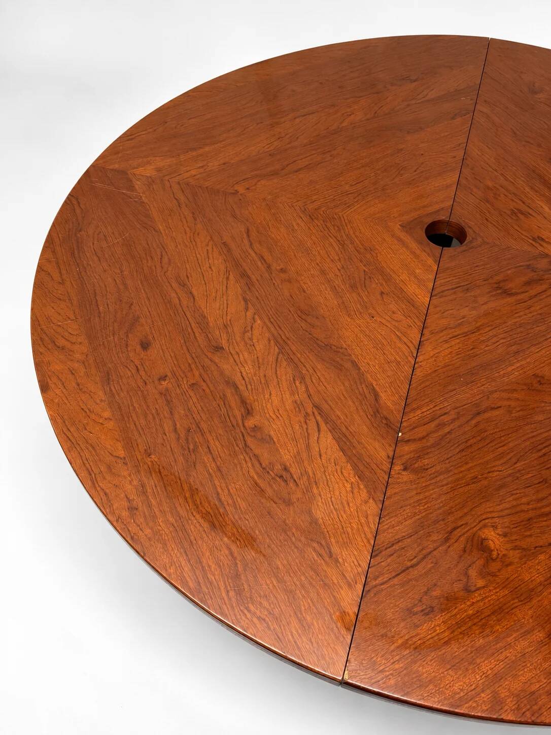 Large round dining table with black blade legs.