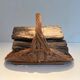 Woven Rattan Log Holder in a Semi-Round Shape with a Central Arched Handle.