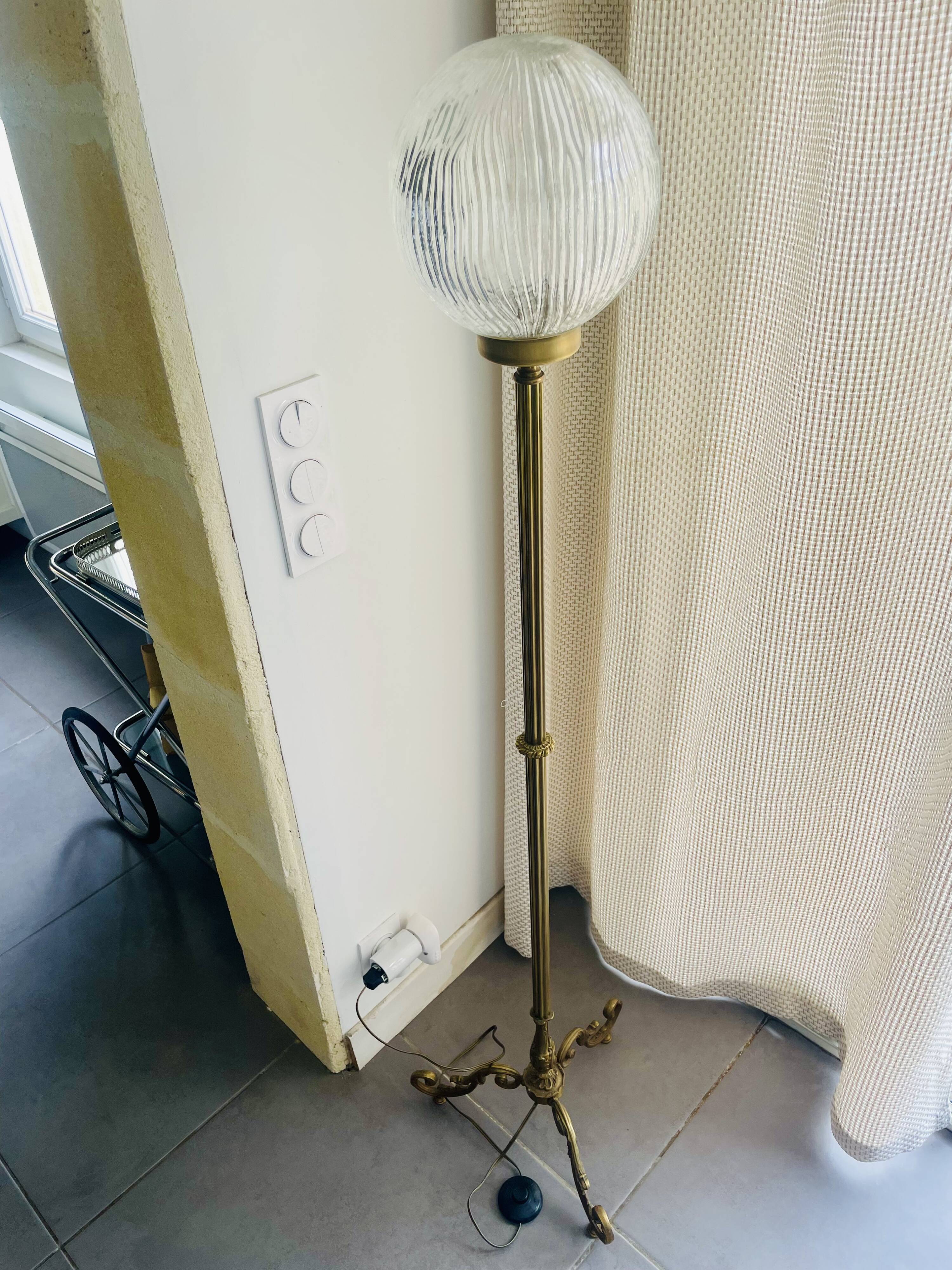 Floor lamp in gilded brass and round glass globe