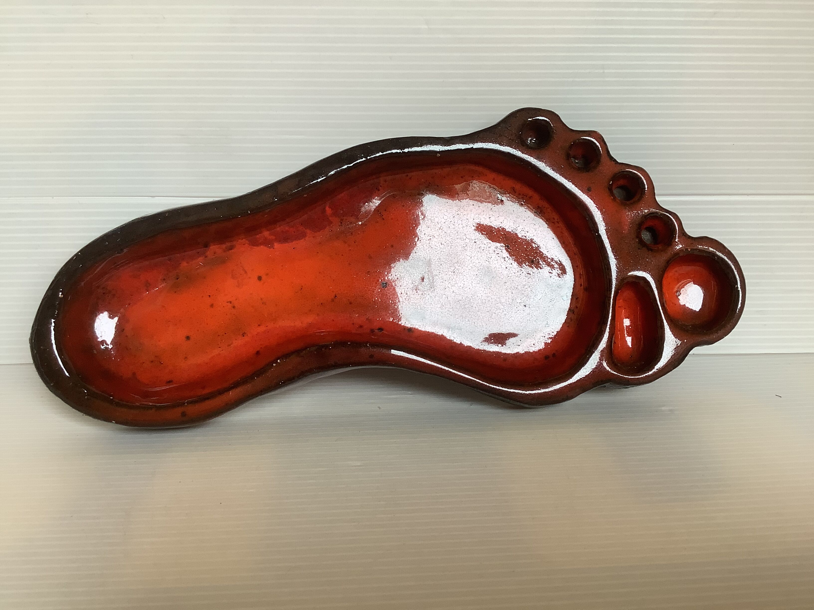 Red ceramic footprint catchall.