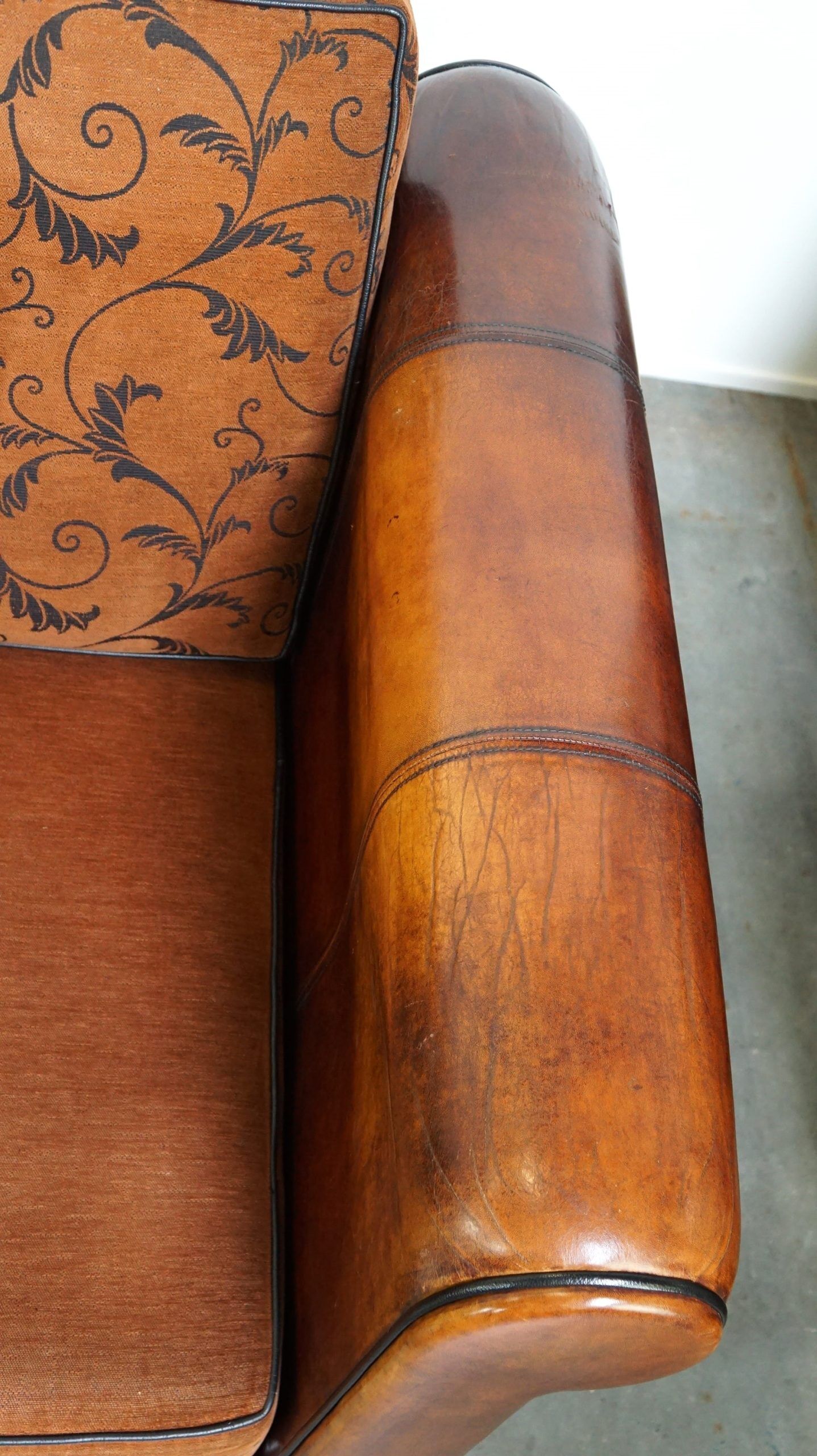 Canapé en cuir de mouton 2,5 places, luxueux et confortable, avec des coussins en tissu.