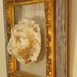 Antique gilded frame with stone lion head ornament on plexiglass