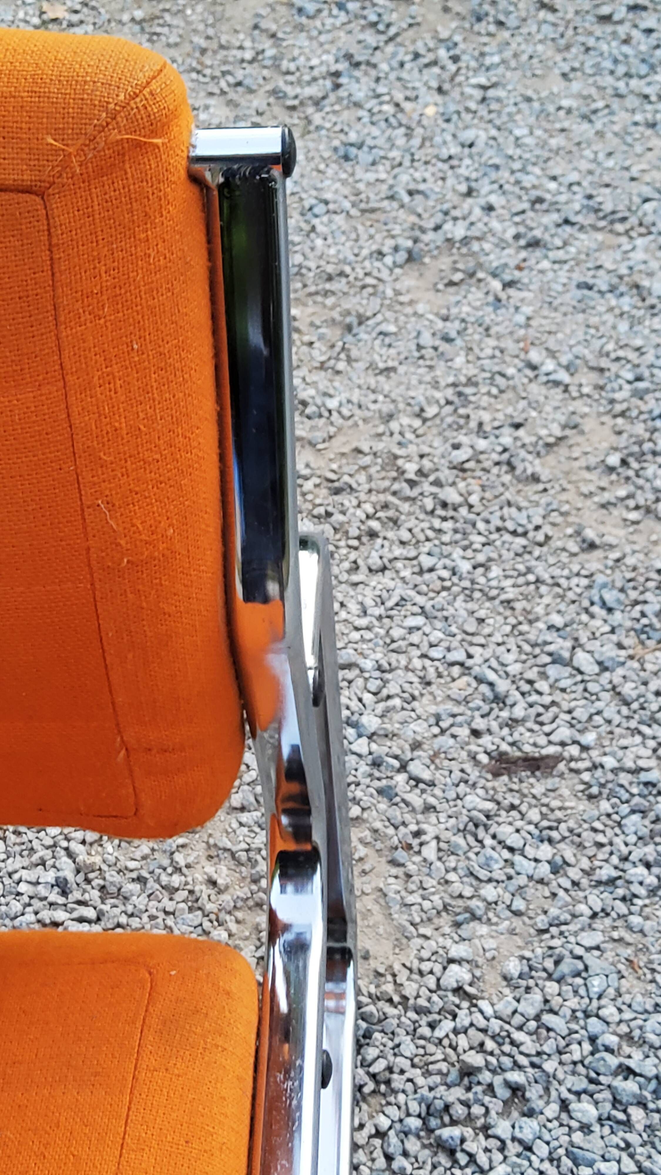 Pair of designer armchairs in orange fabrics and chrome tubes from the 70s