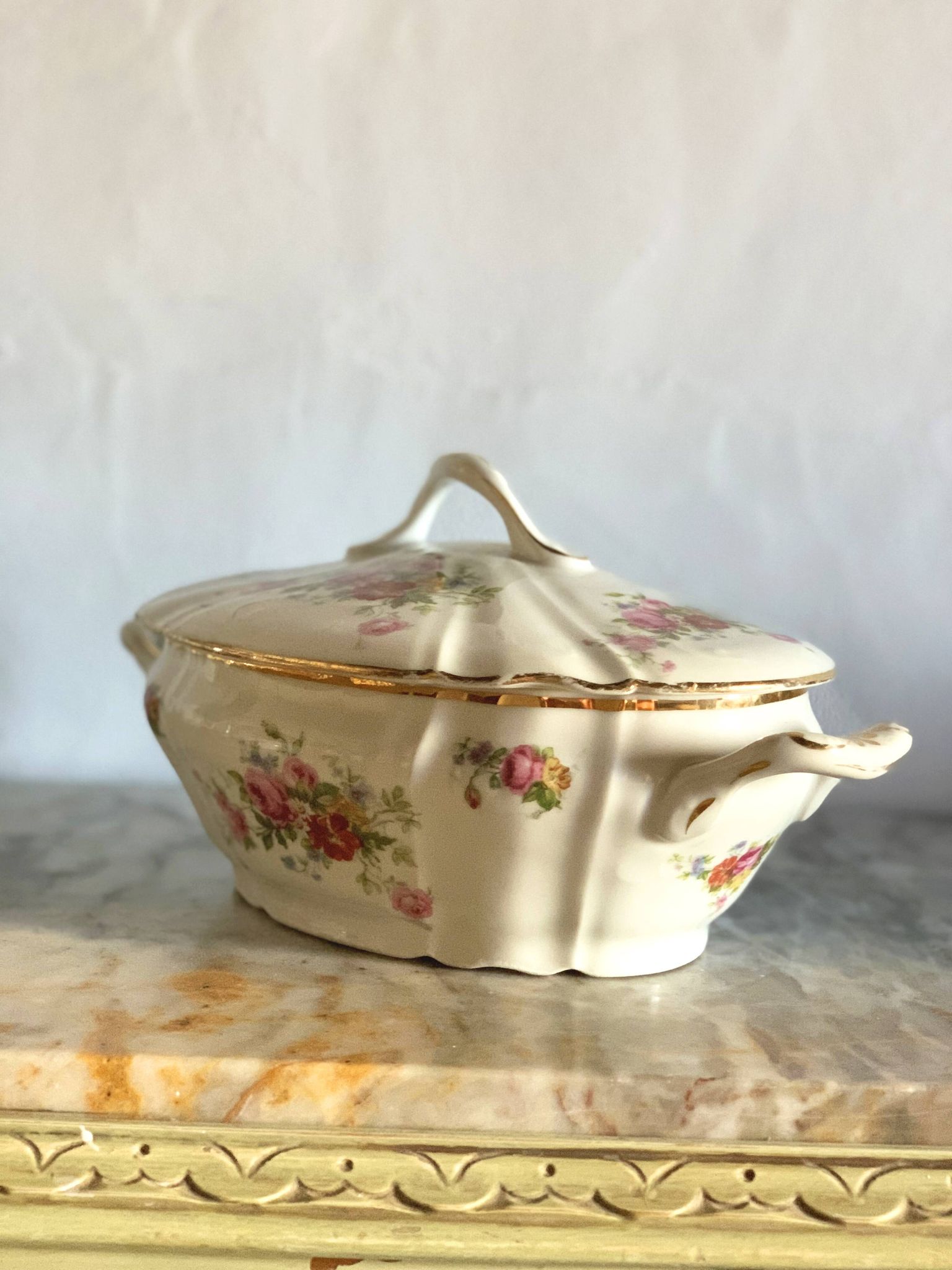 Antique porcelain soup bowl with floral decoration and golden border