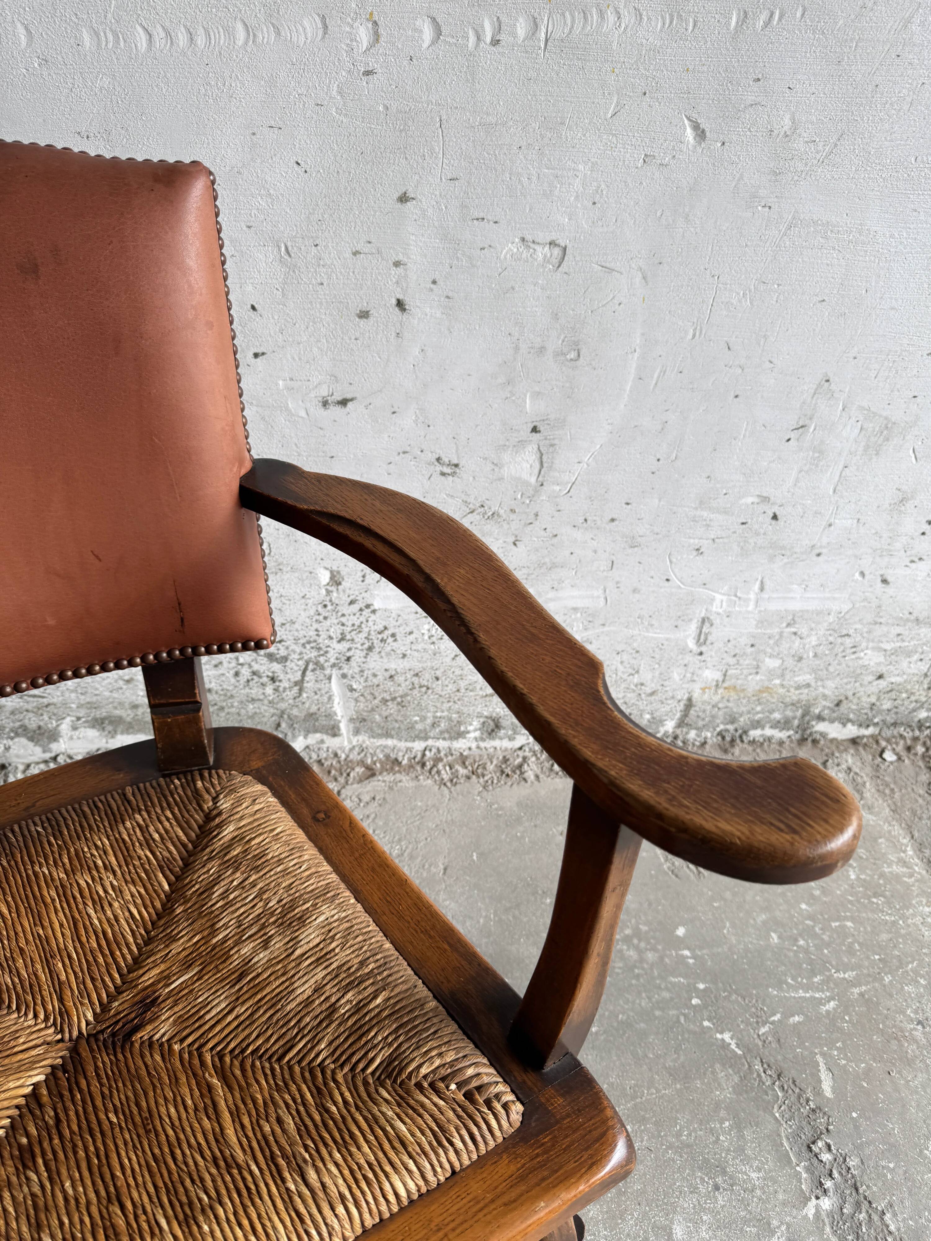 Brutalist dark brown solid wood armchair with natural rattan seat and cognac leather back