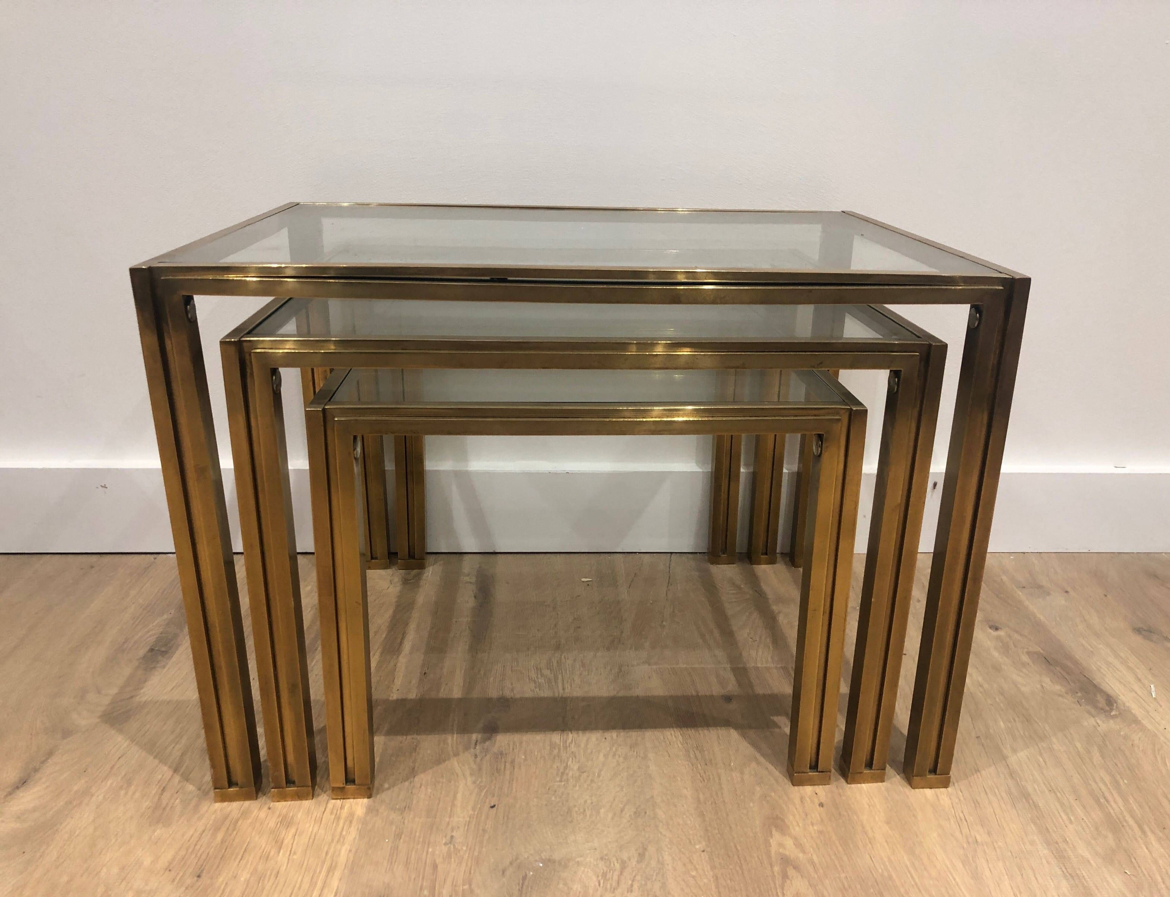 Set of 3 nesting tables in brass and glass. French work by Guy Lef.