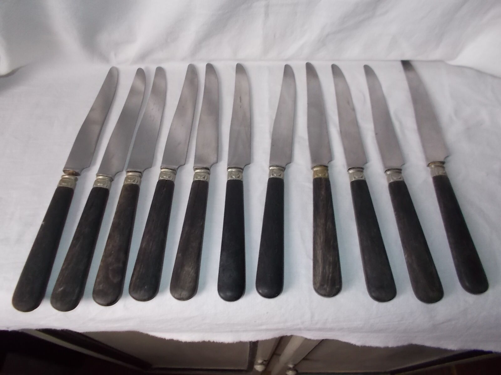 Set of 11 black wooden sleeve knives
