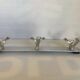 Stainless steel coat rack with three double hooks.