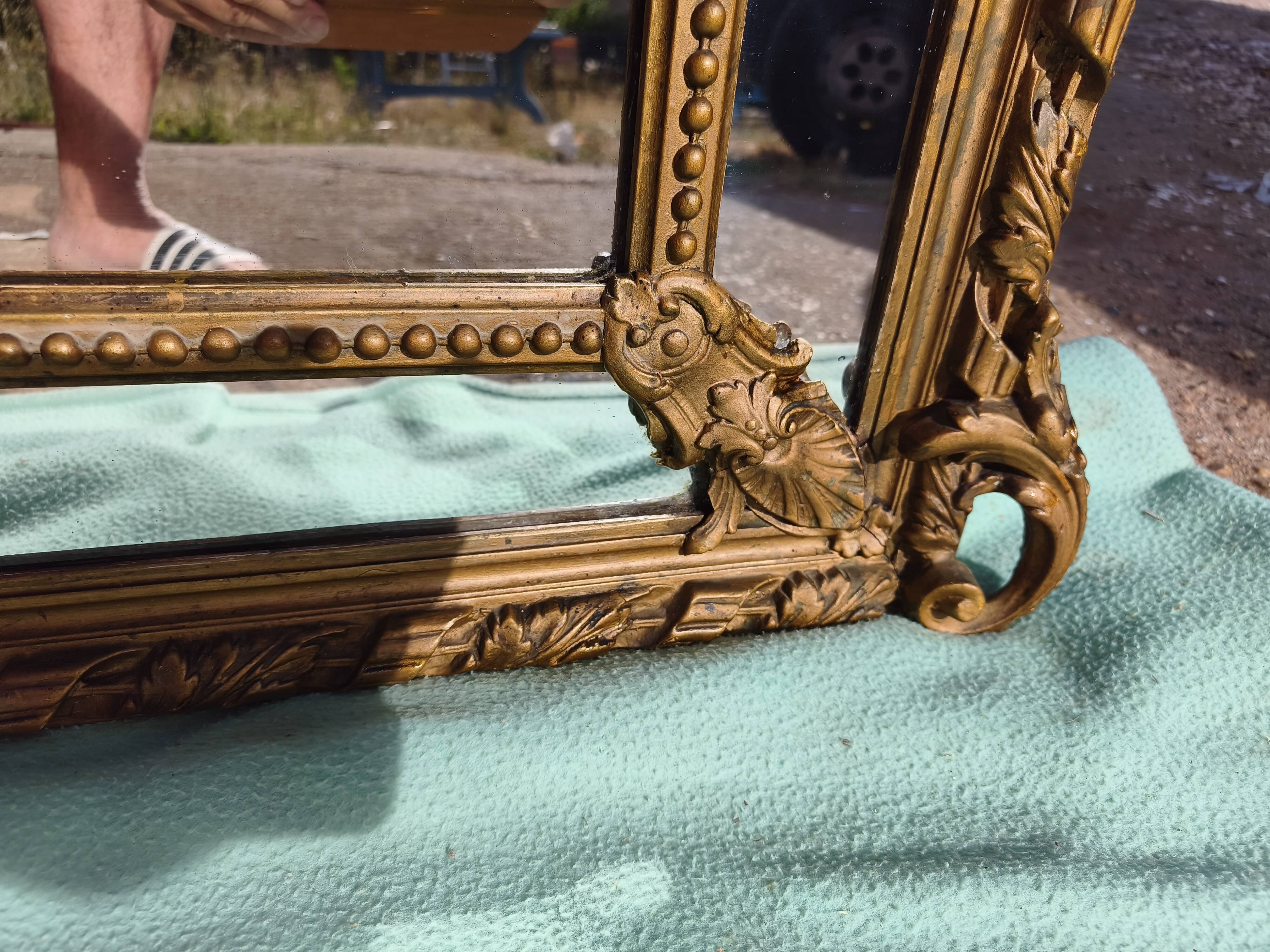 Large closed mirror, 19th century, wood and gilded stucco.