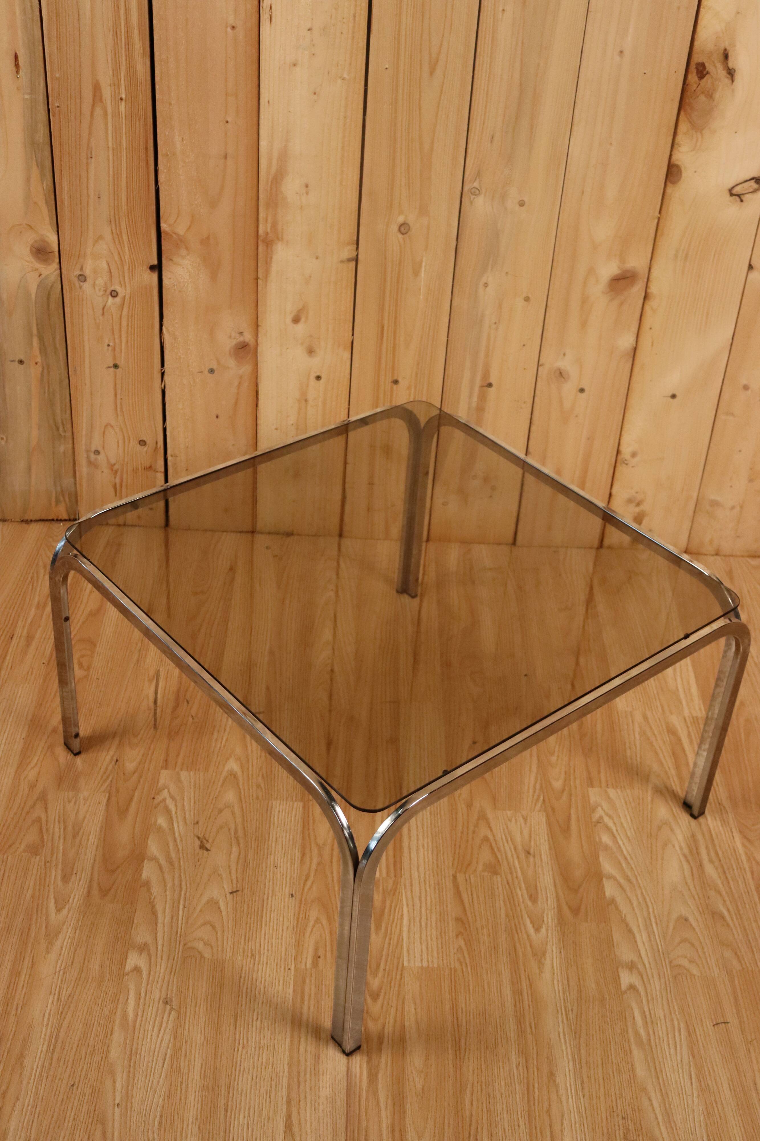 Table basse verre fumé et acier tubulaire.