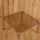 Table basse verre fumé et acier tubulaire.