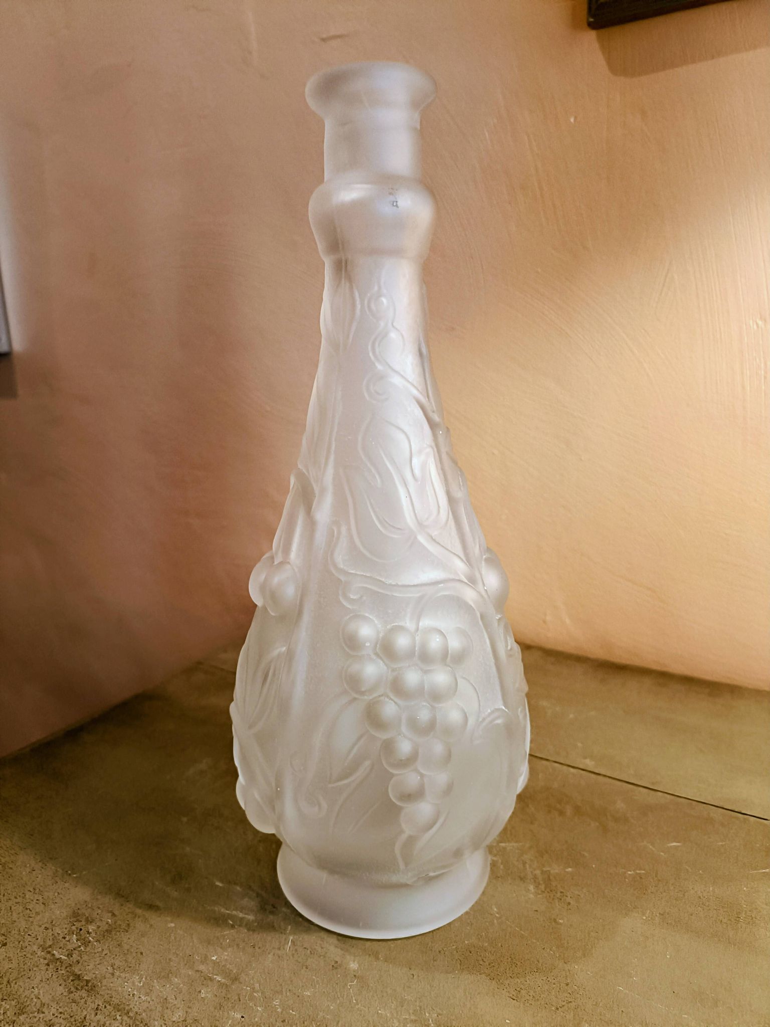 Frosted transparent glass carafe with raised cherry and grape patterns.