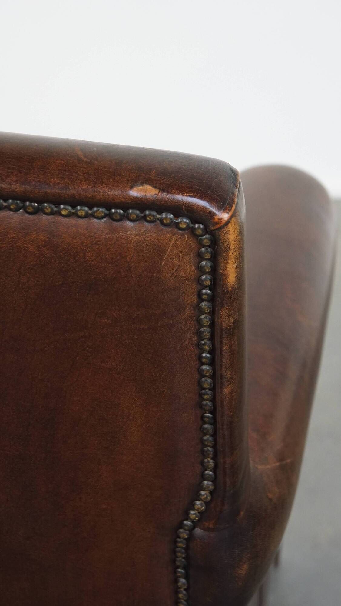 Dark brown sheepskin armchair finished with decorative nails