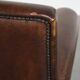 Dark brown sheepskin armchair finished with decorative nails