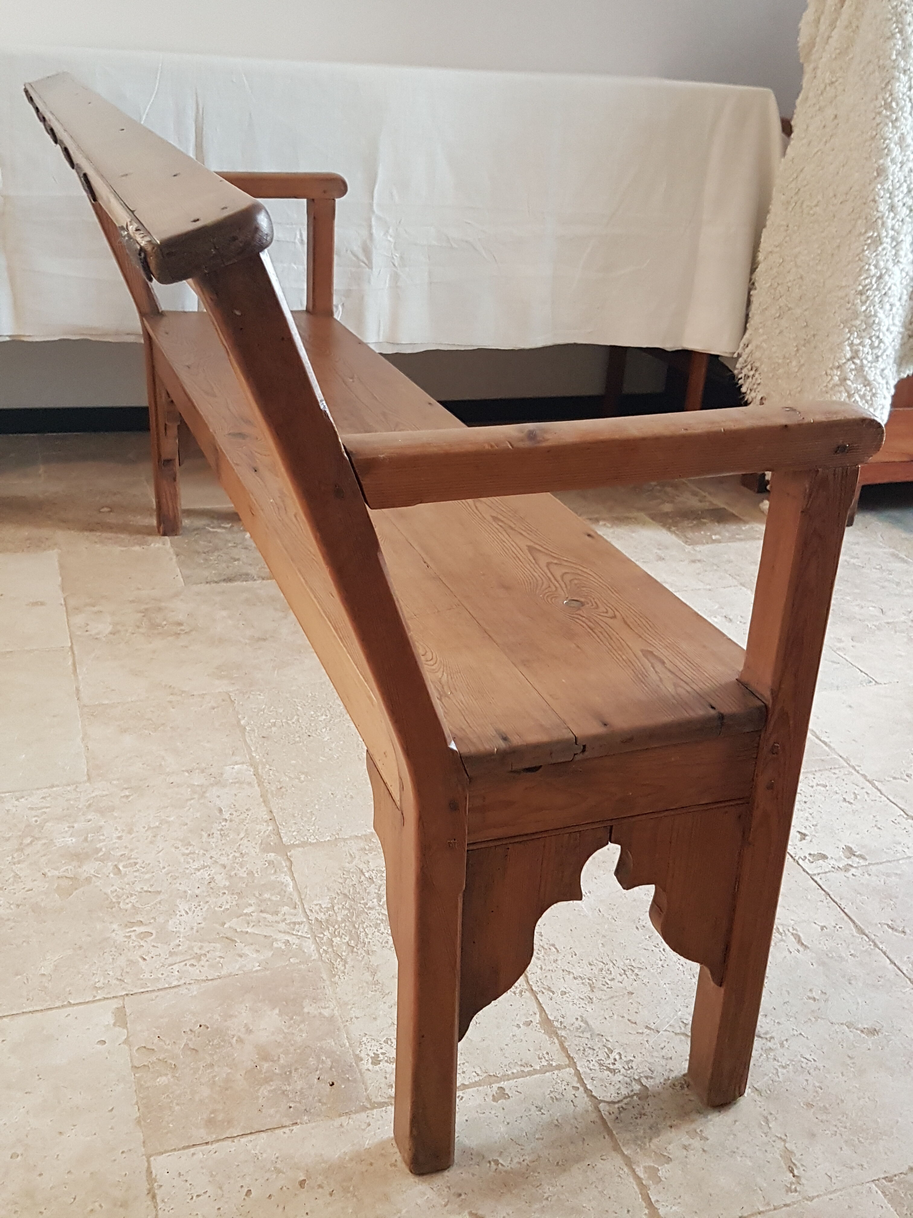 Church bench in fir tree with armrests