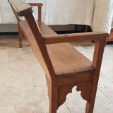 Church bench in fir tree with armrests