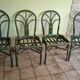Round rattan table with glass top and 4 green rattan chairs.