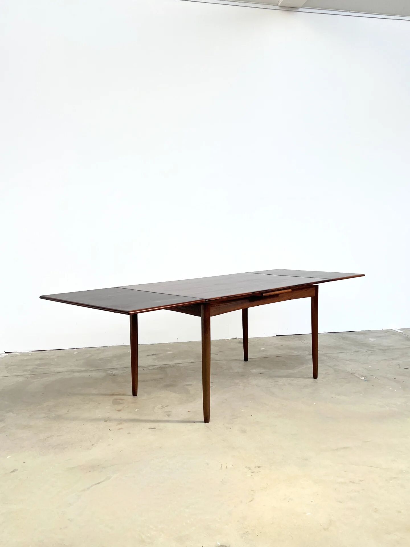 Rosewood dining table with integrated extensions — Denmark, 1960s