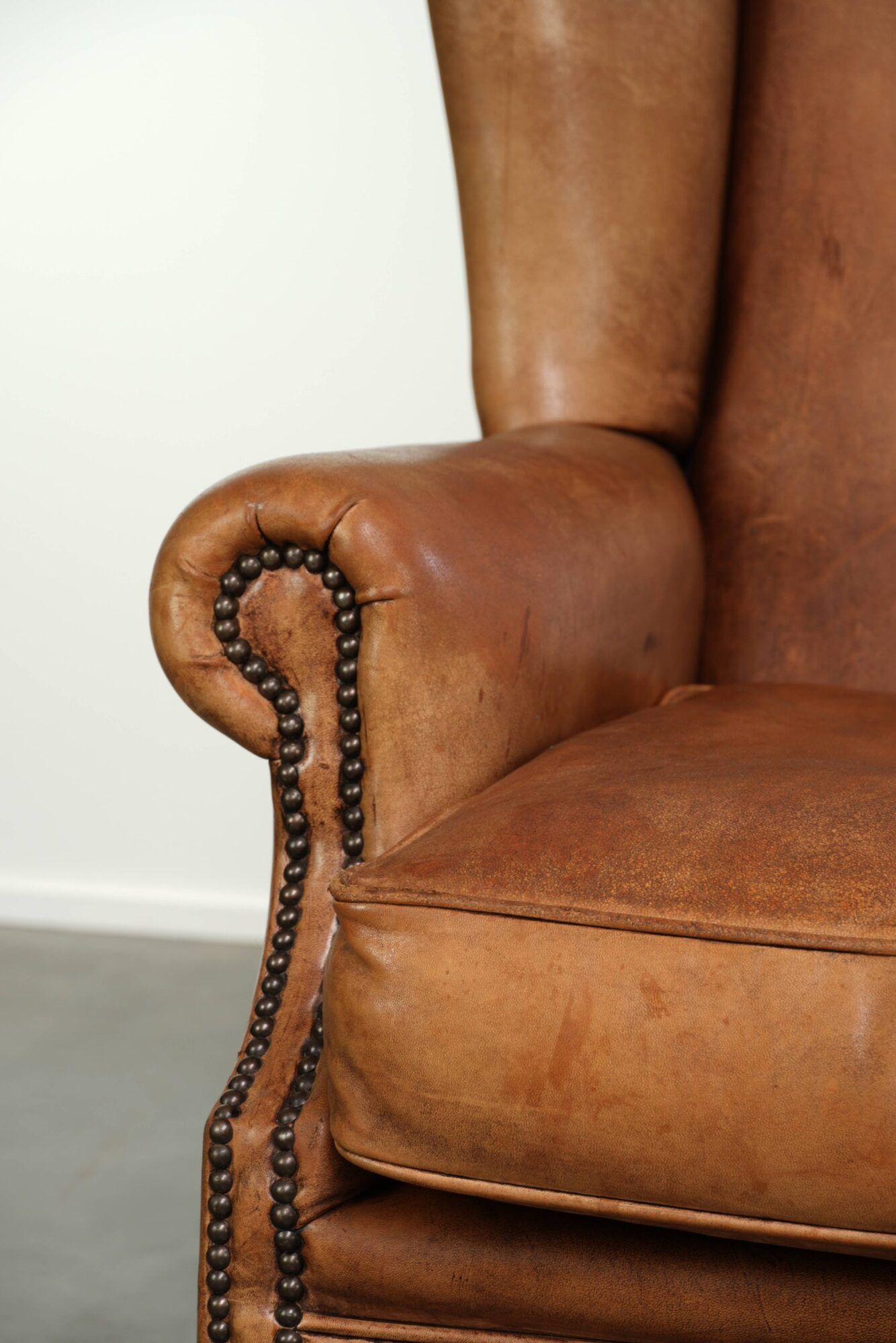 Sheepskin wingback armchair in a light cognac colour in English style