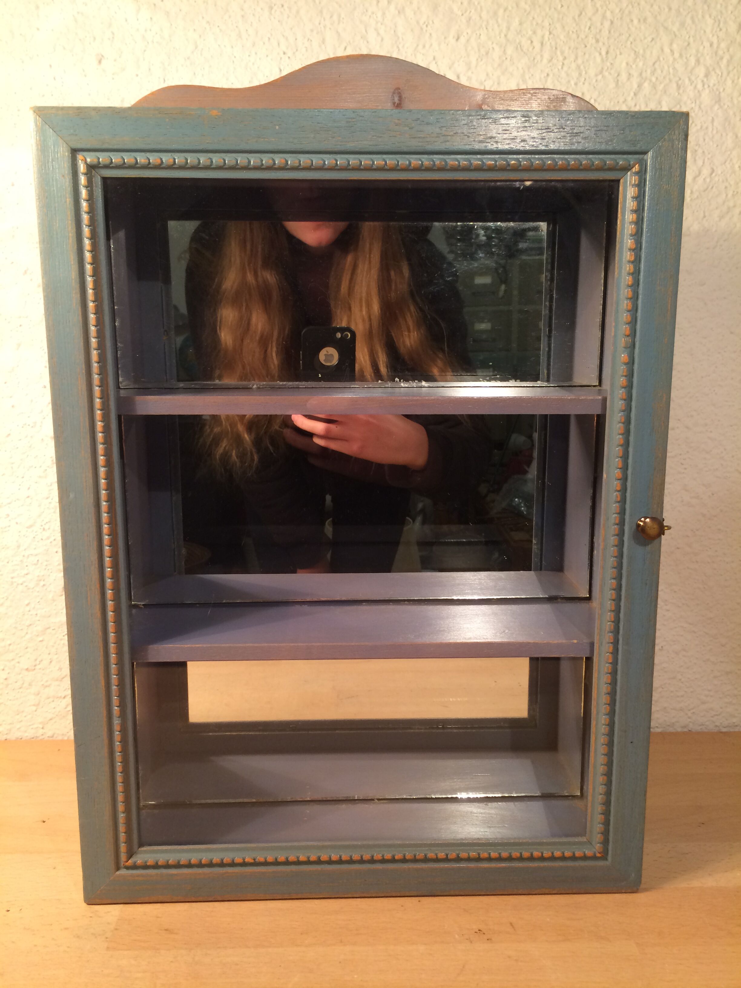 Display shelf with miniature blue wood and mirrors