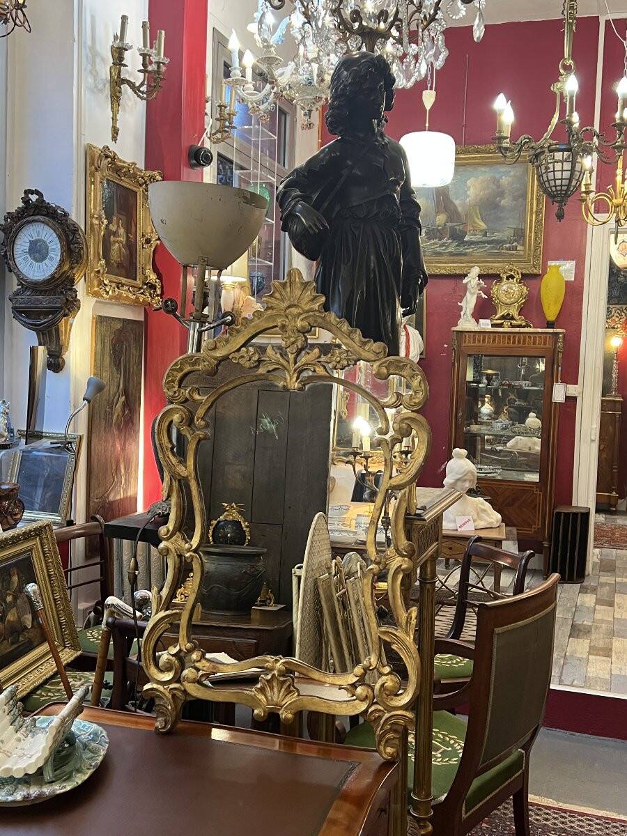 Mirror with carved and gilded wooden frame, 18th century, with scrollwork decoration.