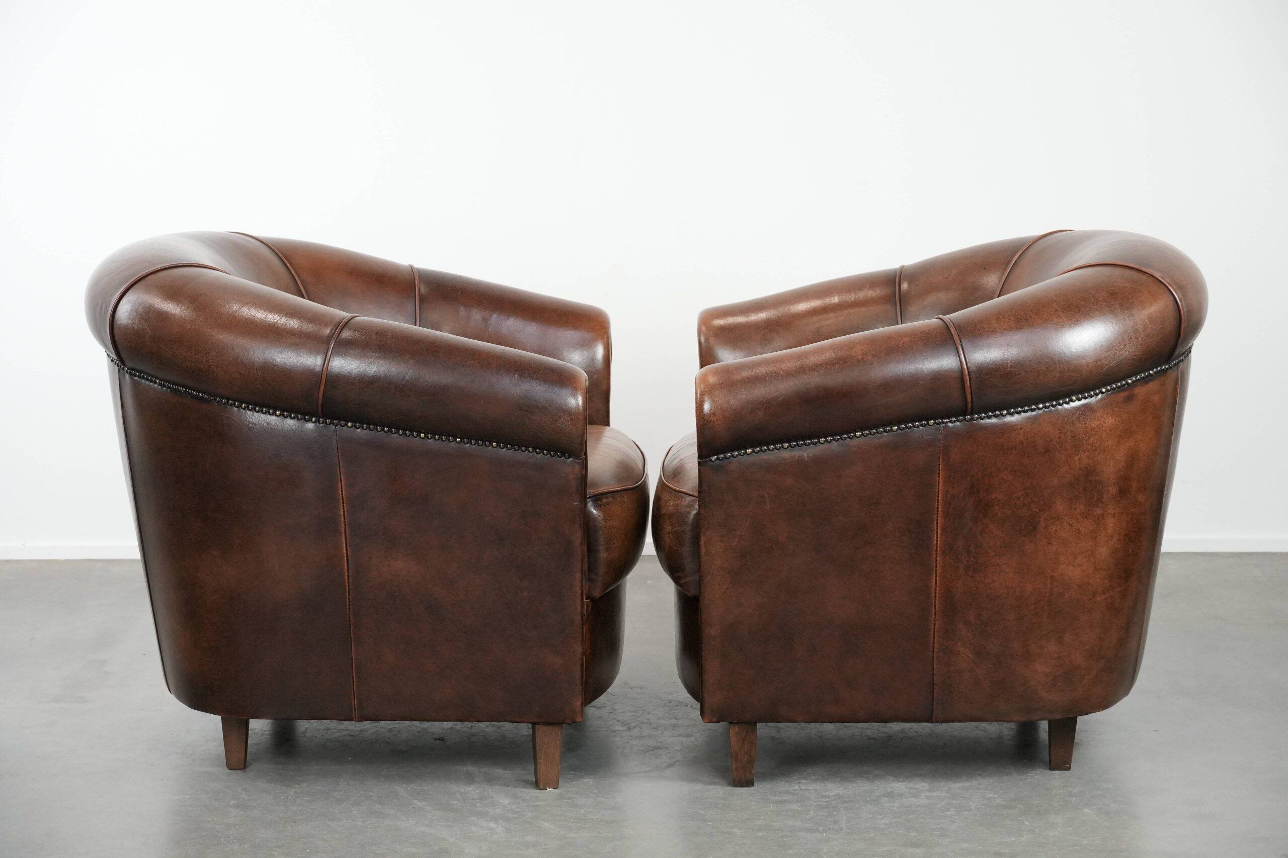 Set of two sheepskin club armchairs with fixed seat cushions