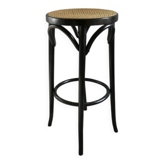 Curved wooden bar stool with a caned seat.