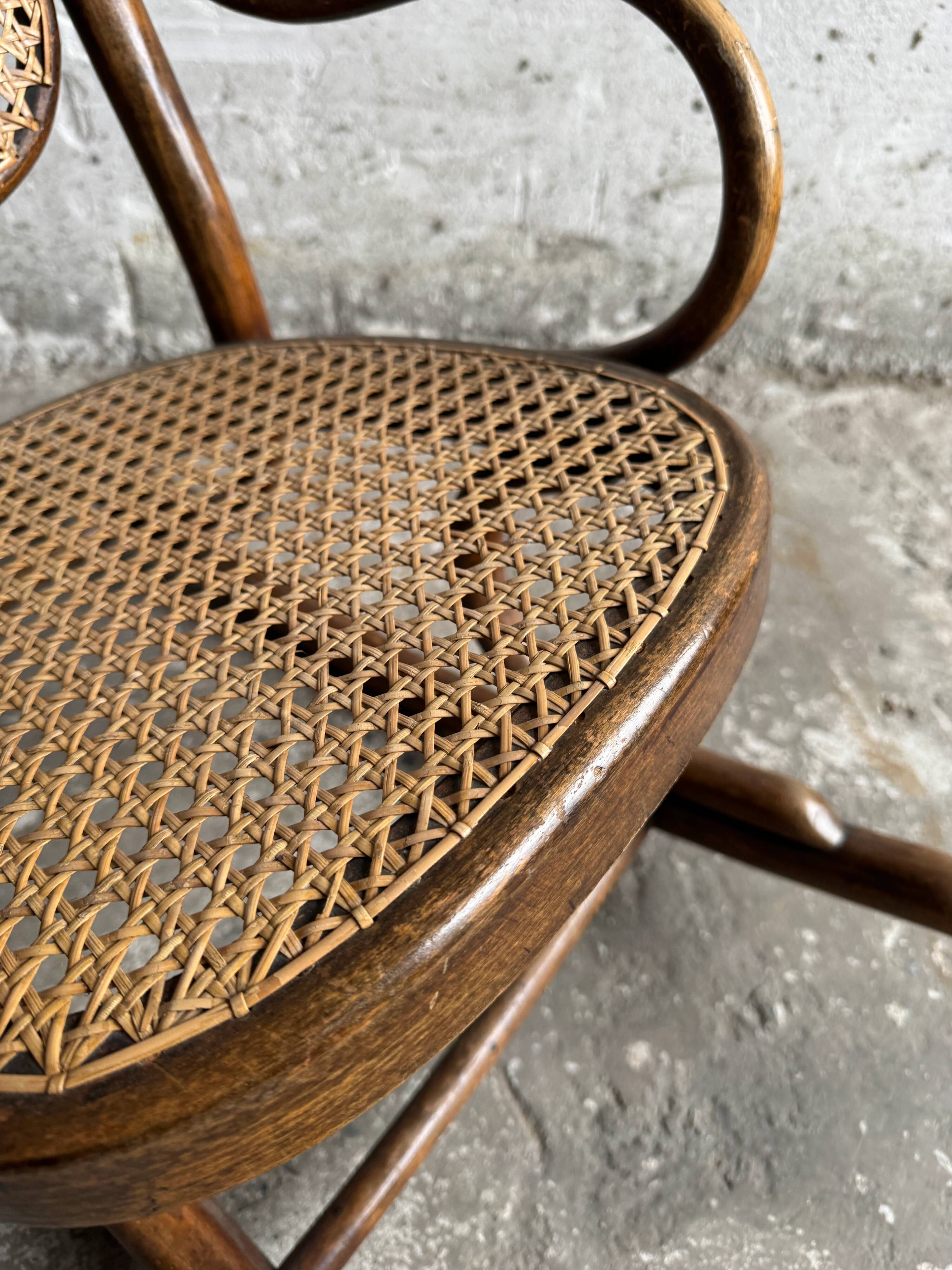 Warm walnut bentwood and cane child's rocking chair early 20th-century