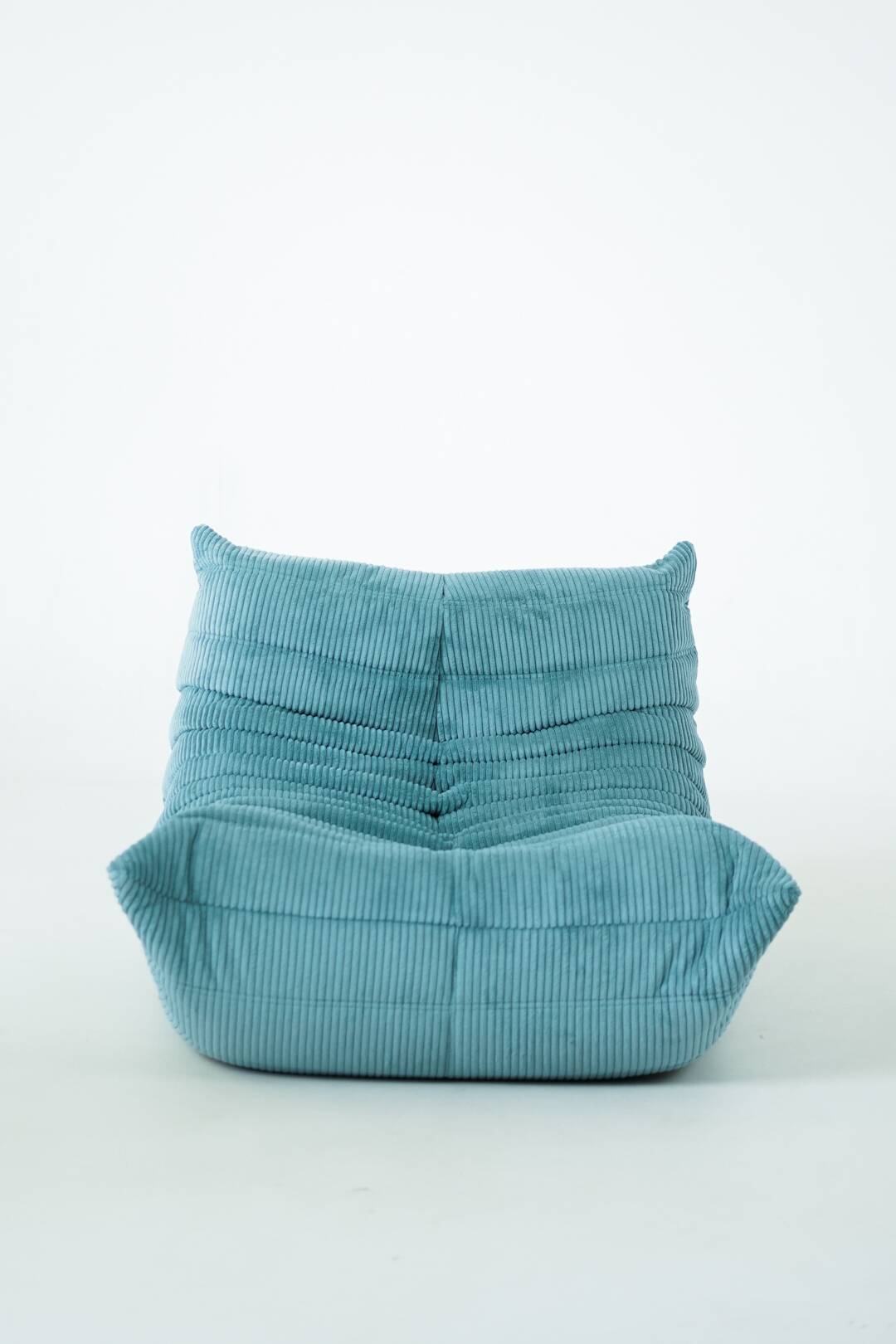 Ensemble de fauteuil et pouf Togo en velours côtelé bleu clair.