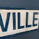 Panneau de signalisation vintage, en bois peint, centre ville.